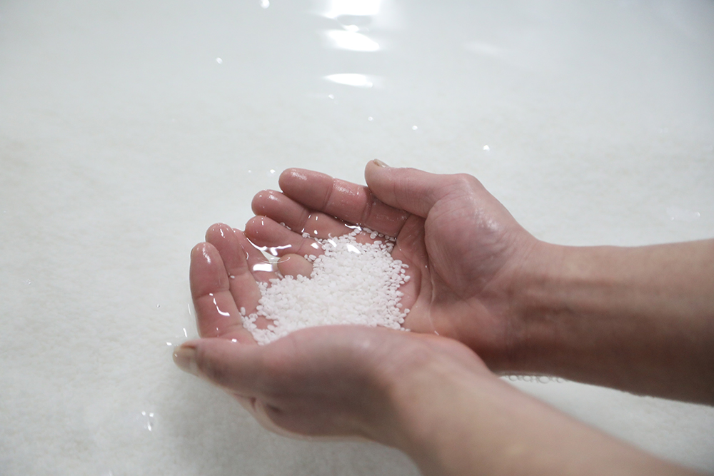 水に浸る手と米